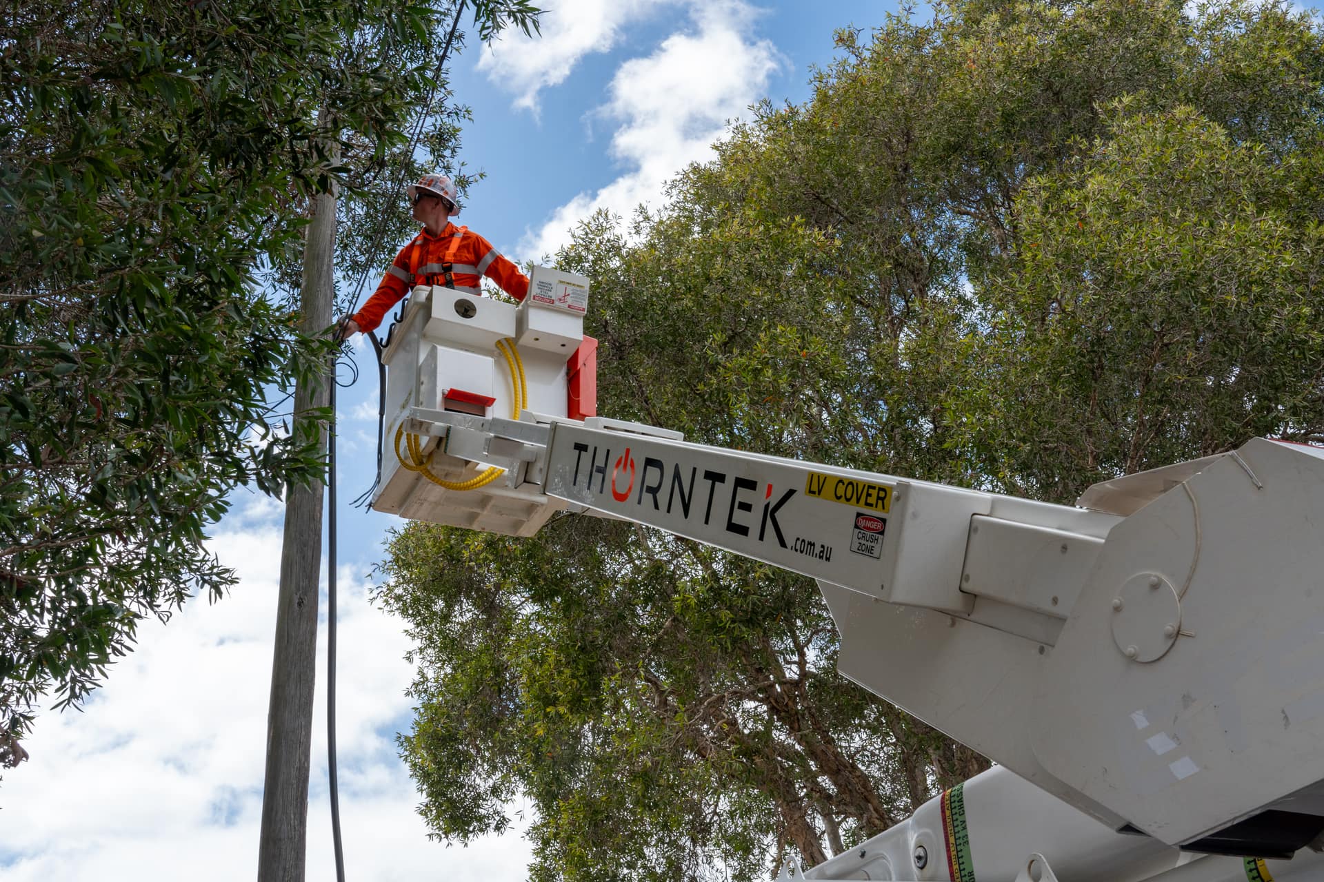 Thorntek elevated work platform on overhead service line work against a clear Sydney sky