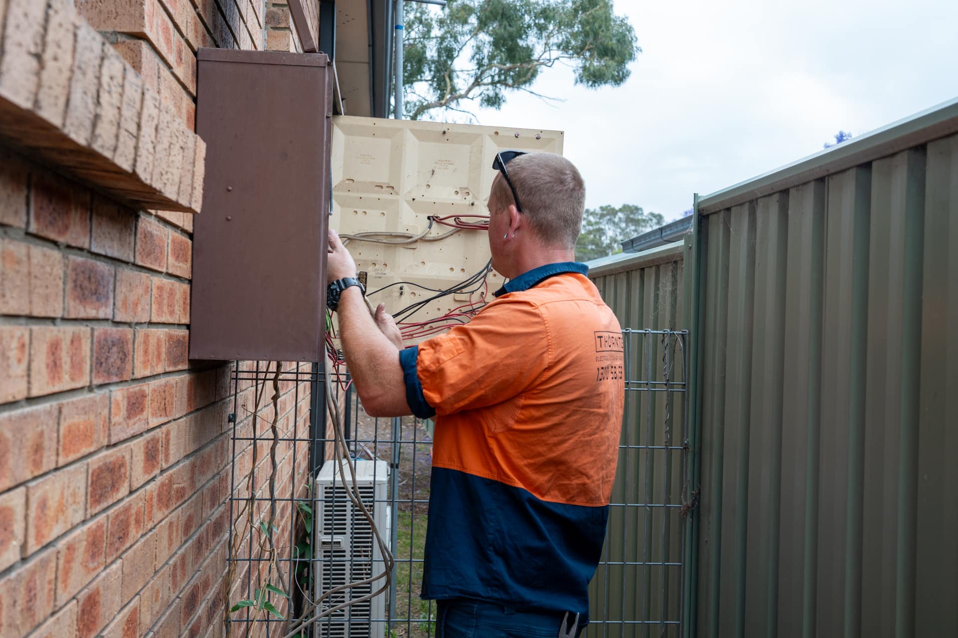 Thorntek electrician in a hard hat rectifying a service connection