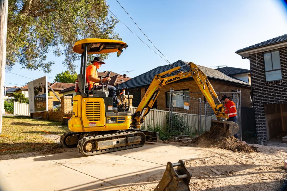 Thorntek excavator trenching a suburban street for an underground electrical run