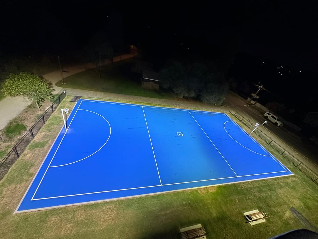 Netball court floodlighting delivered by Thorntek, lit at night