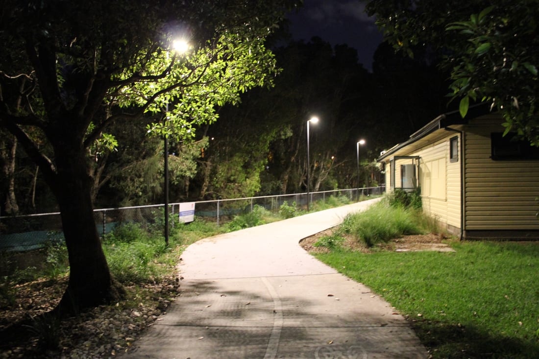 Lit winding pathway past the clubhouse at Blackmore Oval at night
