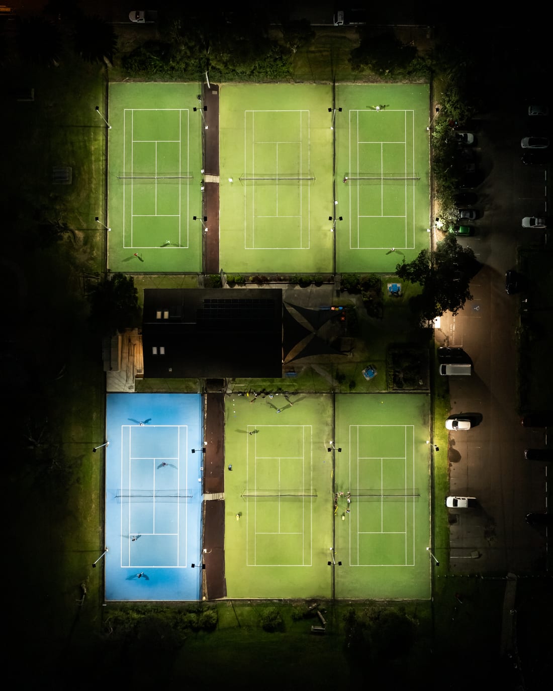 Top-down drone view of the floodlit Collaroy tennis courts at night