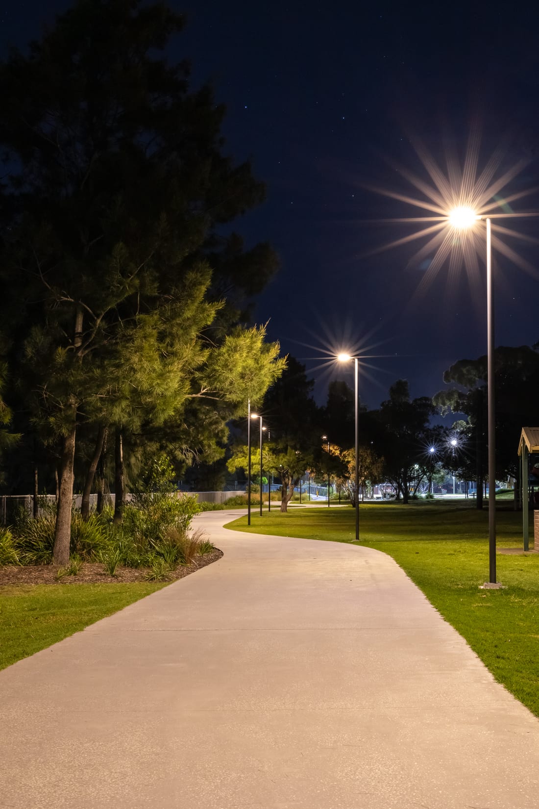 New path lighting with starburst lamps at Richard Murden Reserve at night