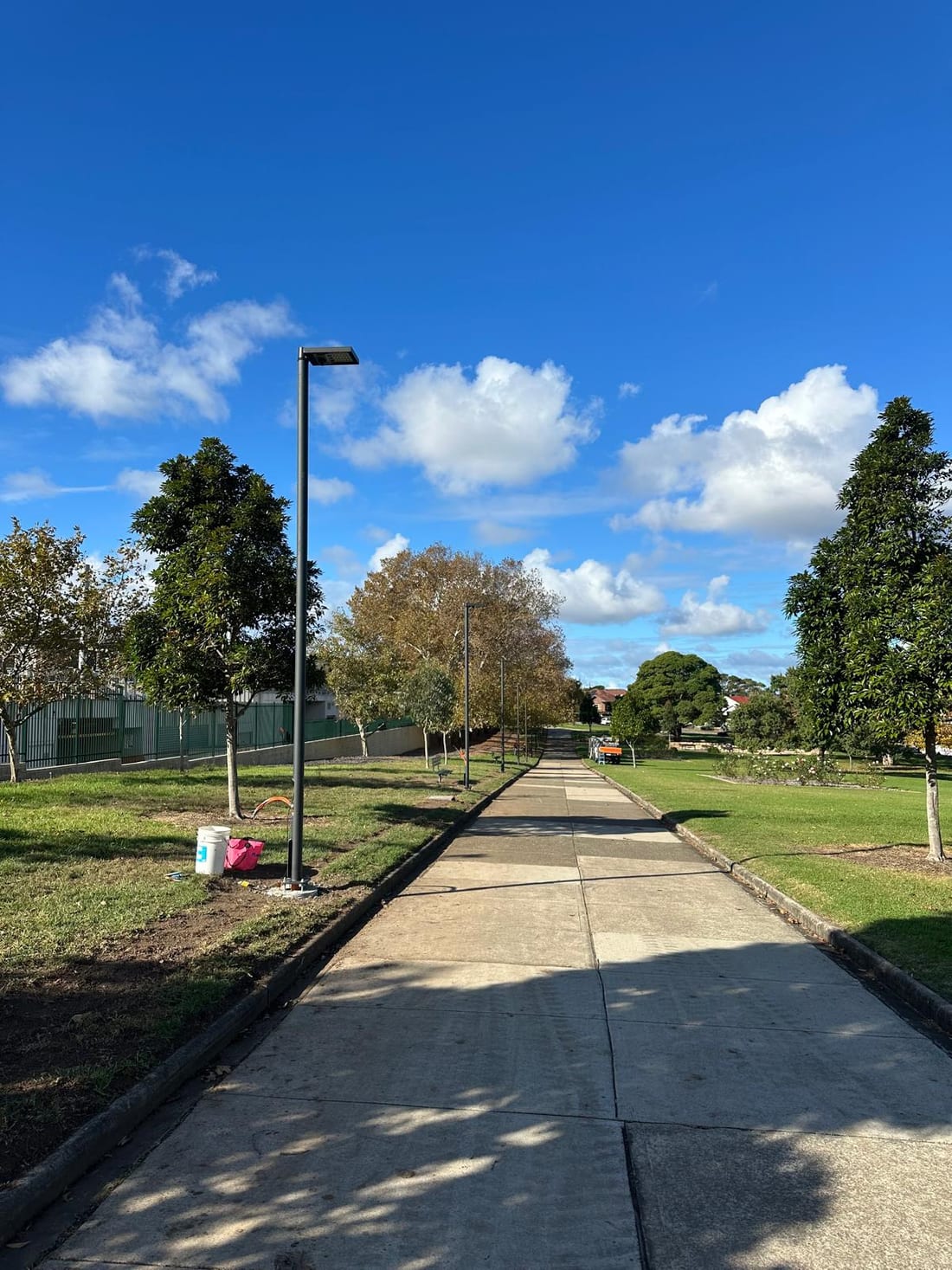 Finished lighting pole and concrete path line under blue sky at Yeo Park